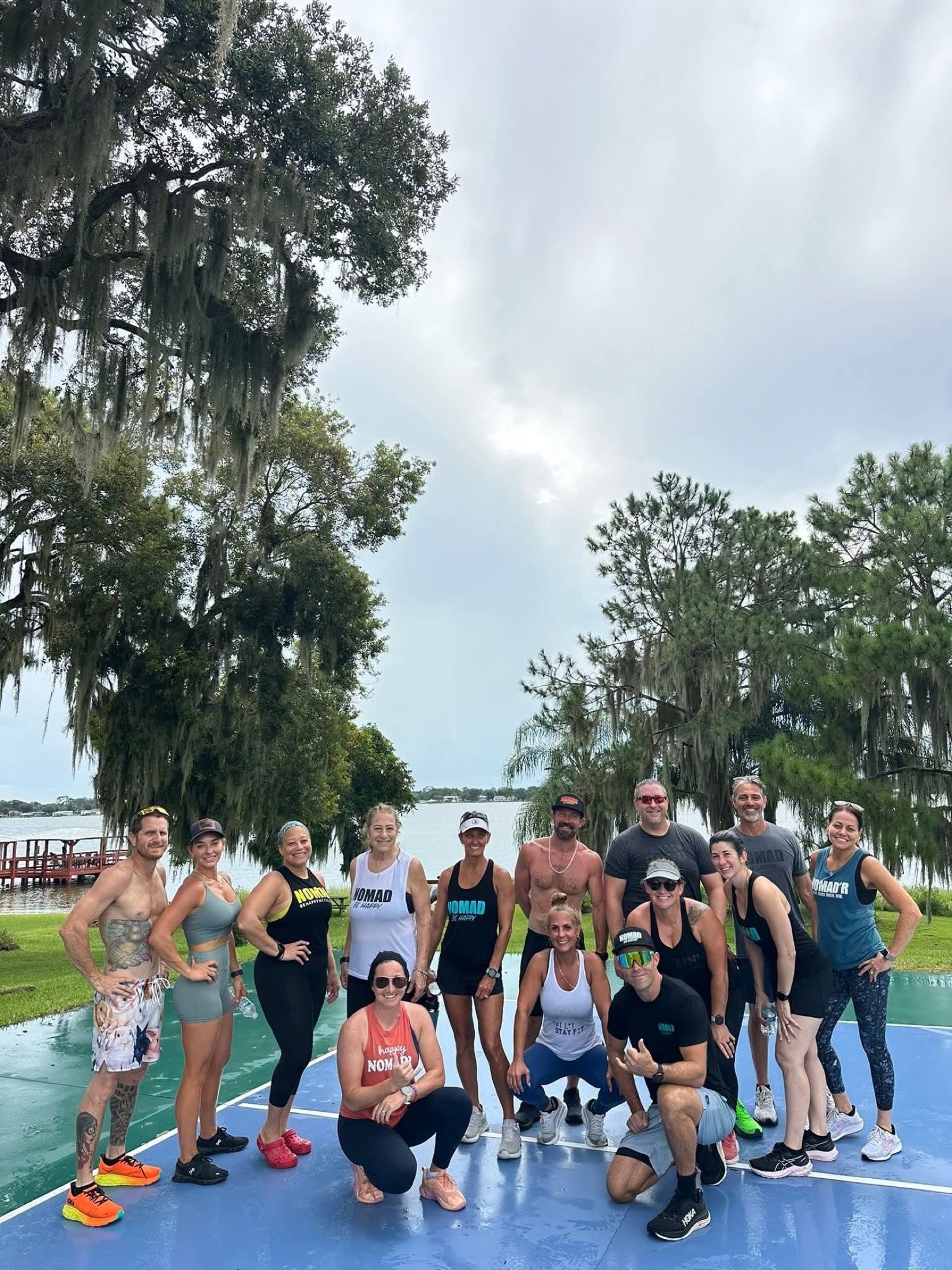A fitness group gathered on the outdoor court beside the lake