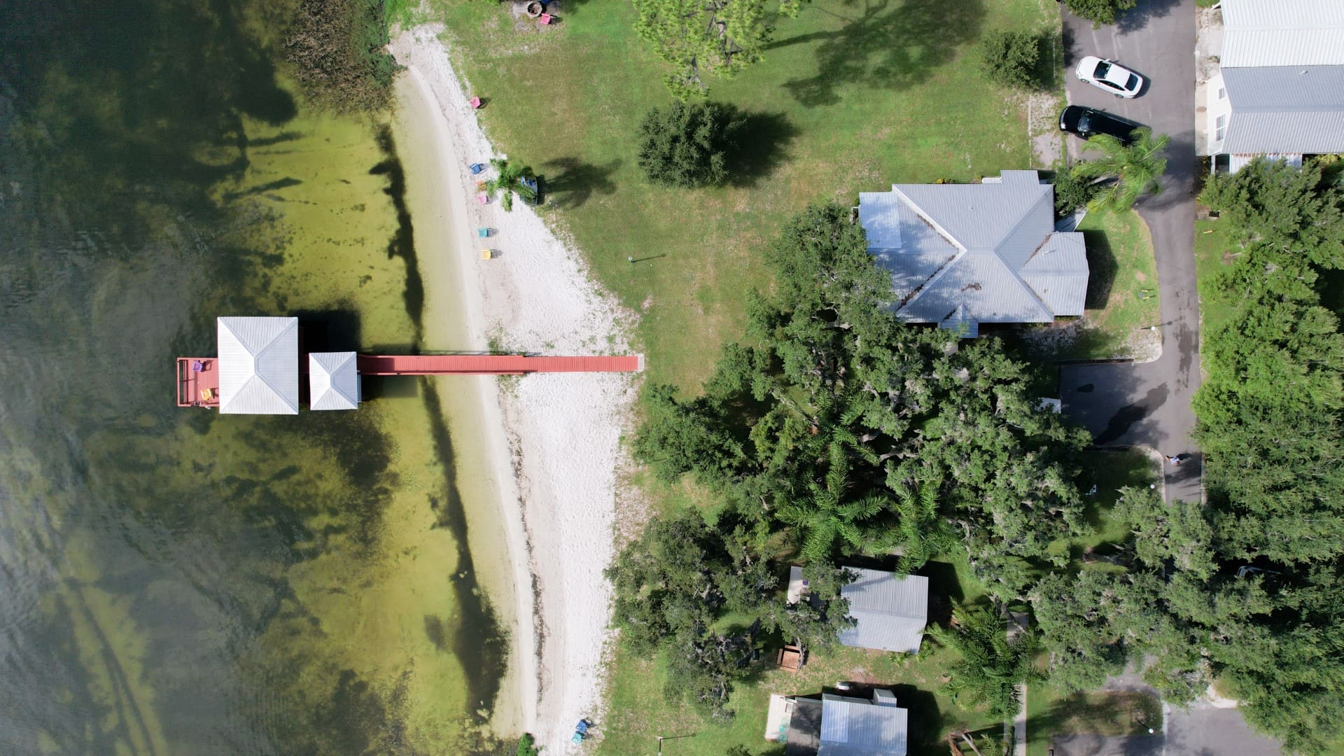 Aerial view of the Lakeside Cottages shoreline, dock, lawn, and cottages