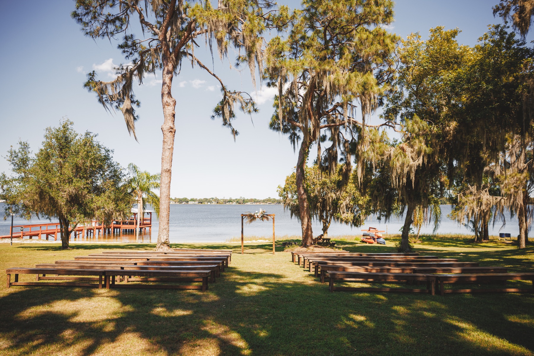 A lakefront wedding ceremony set beneath mature oak trees